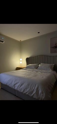 a bedroom with a large white bed with a lamp at Studio in Al-Aqiq شقه رقم 15 و in Riyadh