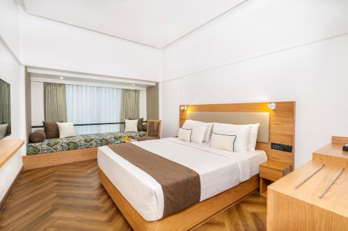a hotel room with a large bed and a couch at Hotel Kohinoor Continental, Airport - Newly Renovated in Mumbai