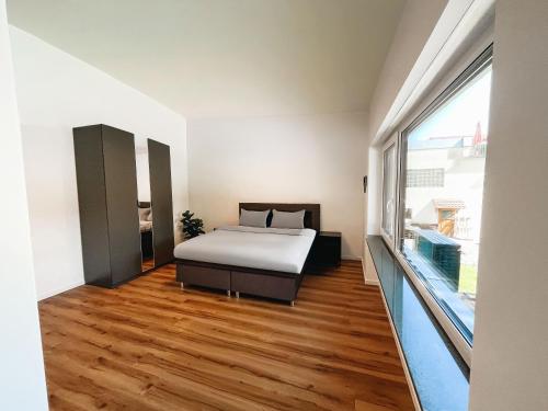 a bedroom with a bed and a large window at Frisch renoviert & gemütlich mit Terasse in Sulzbach