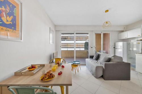 a kitchen and living room with a table and a couch at PALACIO- Centre-Ville - Parking privé - Proche Mer - Grande terrasse in Menton