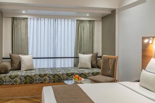 a hotel room with a bed and a chair at Hotel Kohinoor Continental, Airport - Newly Renovated in Mumbai