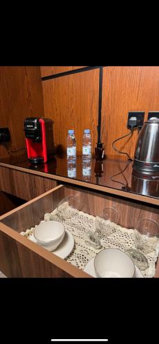 a counter with two white plates and a coffee maker at Studio in Al-Aqiq شقه رقم 15 و in Riyadh