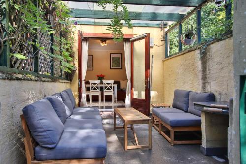 a patio with two blue couches and a table at Gite Havre de Soy in Soy