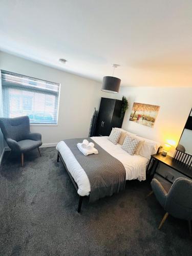 a bedroom with a large bed and a chair at Yastayzzz at Studio 4 Bransford Rd in Worcester