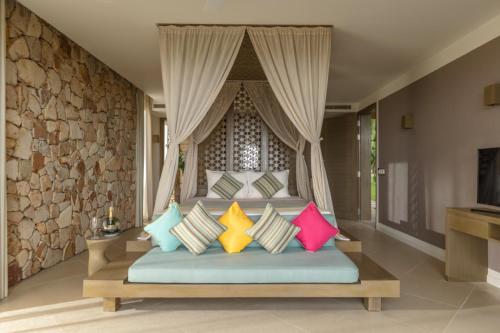 a bedroom with a bed with colorful pillows at Mia Resort Nha Trang in Nha Trang