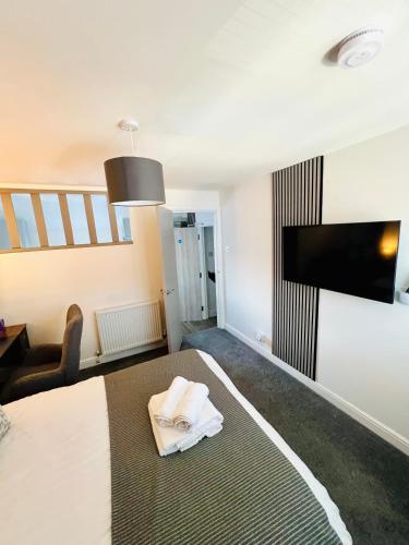 a hotel room with a bed and a flat screen tv at Yastayzzz at Studio 4 Bransford Rd in Worcester