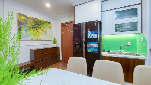 a kitchen with a refrigerator and a table and chairs at The 1108 sapphire Ha Long in Ha Long