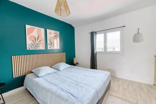 a bedroom with a blue accent wall and a bed at Appartement Spacieux 80 m2 in Bobigny