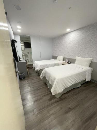 a hotel room with two beds and a television at 歐法行旅 O Fun Hotel in Taipei