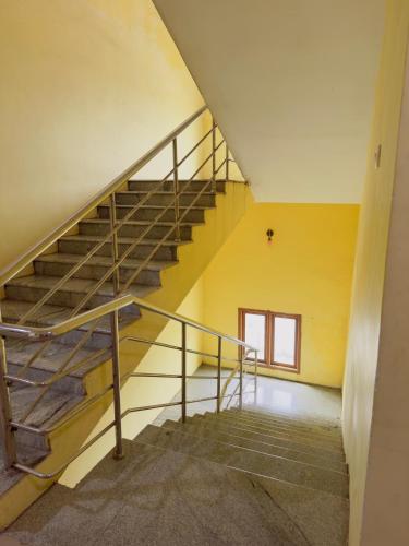 a staircase in a building with a yellow wall at Hotel City Towers, Nagore in kāraikāl