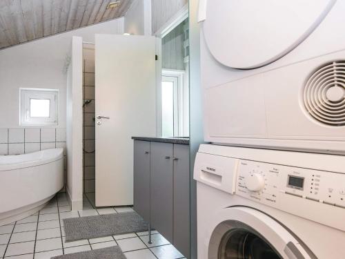 a bathroom with a washer and dryer at 8 person holiday home in Hjørring-By Traum in Lønstrup