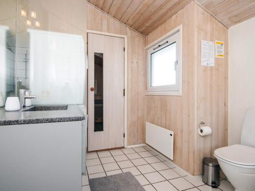 a bathroom with a toilet and a sink and a window at 8 person holiday home in Hjørring-By Traum in Lønstrup