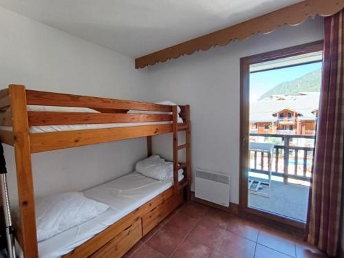 a bedroom with two bunk beds and a large window at Résidence Les Airelles - appartement en duplex - Garage couvert - 50 m des pistes de ski MAE-4114 in Montgenèvre