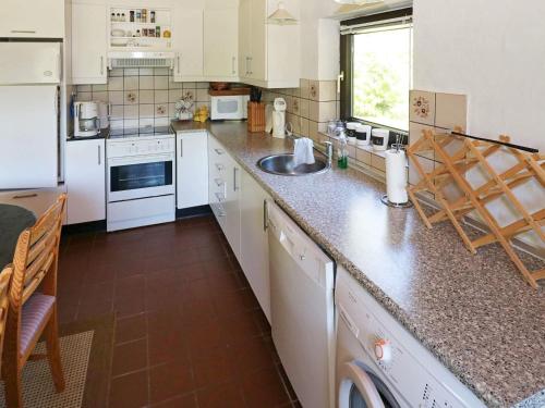 a kitchen with white appliances and a counter top at Cozy Cottage near Mariager - By Traum Ferienwohnungen in Odde