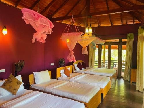 a room with four beds with umbrellas hanging from the ceiling at Ever After - Ella, Sri Lanka in Ella