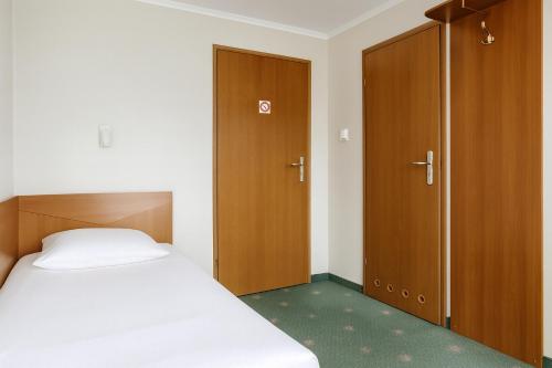 a bedroom with a bed and two wooden cabinets at Hotel Victory Home in Warsaw