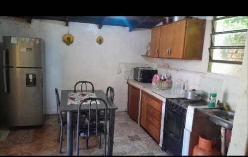 cocina con mesa, fogones y nevera en Marce Alojamiento, en Cambyretá