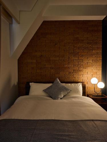 a bedroom with a large bed with a brick wall at R STAY Shiba in Tokyo