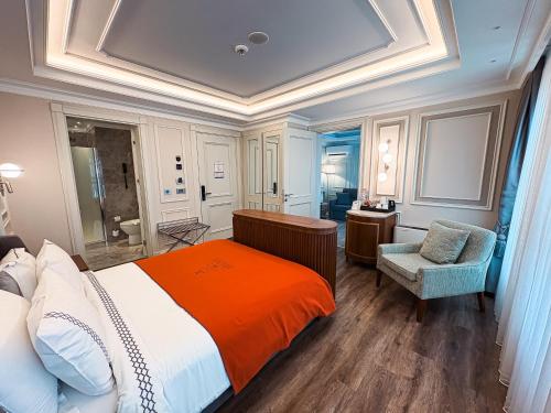 a bedroom with a large bed and a chair at Amiral Palace Hotel Boutique Class in Istanbul