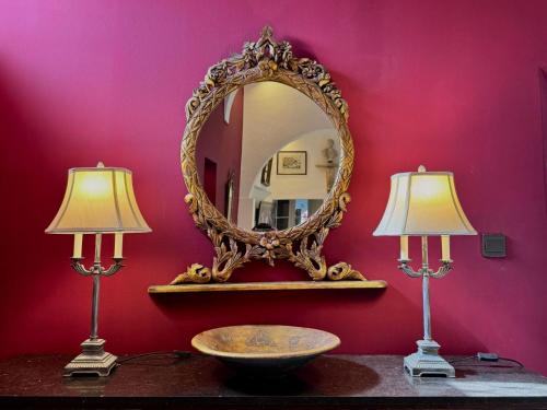 a mirror on a wall with two lamps on a table at Palazzo dei Fiori since 1883 in Ħal Balzan