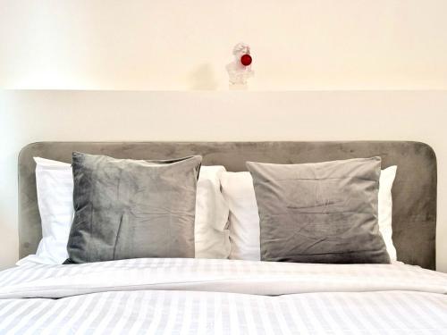 a bed with a gray headboard and pillows at Palazzo dei Fiori since 1883 in Ħal Balzan