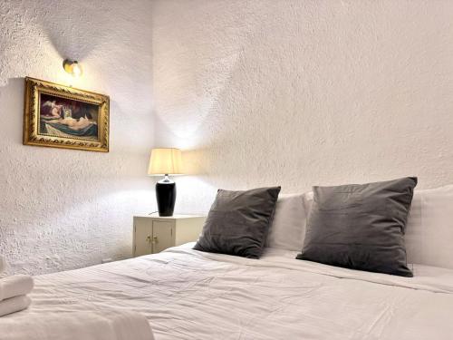 a white bed with two pillows in a bedroom at Palazzo dei Fiori since 1883 in Ħal Balzan