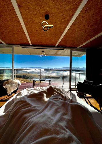 a bed in a room with a large window at Cabana panorâmica in Cunha