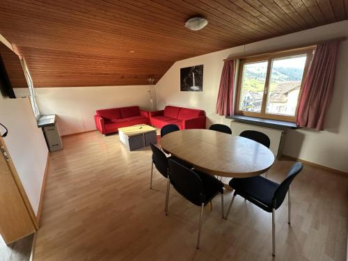 Una sala de estar con una mesa y sillas y un sofá. en Bergnest Wildhaus, en Wildhaus
