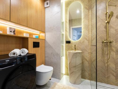 グダニスクにあるKazimierza Wielkiego Soft Glam Apartment by BookingHostのトイレとガラスのシャワー付きのバスルーム