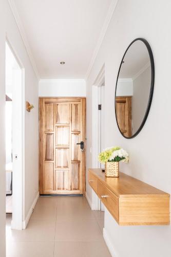 a hallway with a mirror and a wooden door at Beautiful Condo just steps from Avenida Escazu in an unbeatable location in San Rafael
