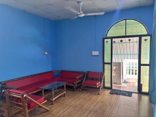 a room with a red bench and a blue wall at Siv villa in Kāhārpāra