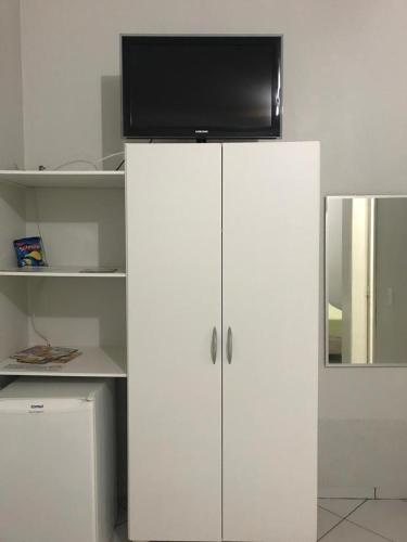 a white cabinet with a television on top of it at Hotel Master in Primavera do Leste