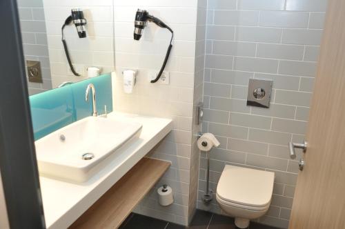 a bathroom with a sink and a toilet at Holiday Inn Express - Sindelfingen by IHG in Sindelfingen