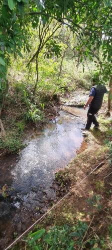 a man is walking through a stream of water at Chalecitos del Carmen in Carmen del Paraná