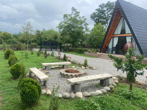 a garden with benches and a fire pit in front of a building at Chalet Martvili in Martvili