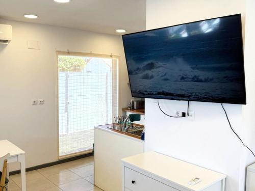 a kitchen with a large flat screen tv on a wall at Nómada Hostel in El Palmar
