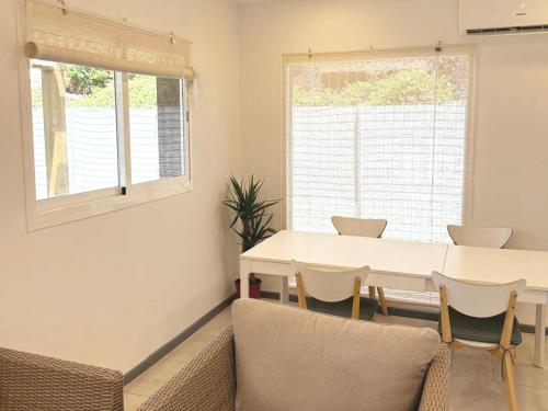 a dining room with a white table and chairs at Nómada Hostel in El Palmar