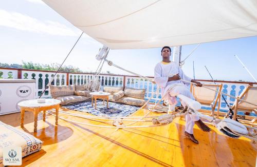 a man sitting on the deck of a boat at Sky Sail Dahabiya in Aswan