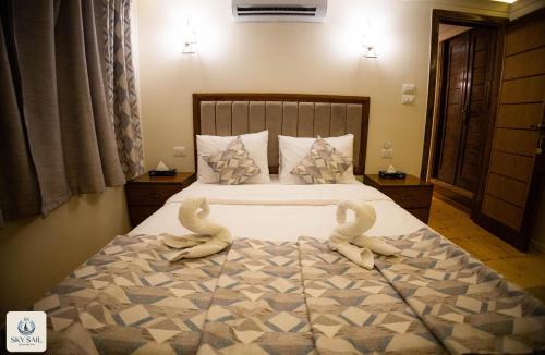a bedroom with a bed with two swans on it at Sky Sail Dahabiya in Aswan