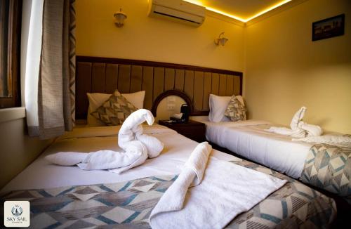 two swans sitting on beds in a hotel room at Sky Sail Dahabiya in Aswan