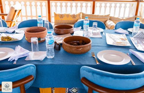 a blue table with plates and water bottles on it at Sky Sail Dahabiya in Aswan