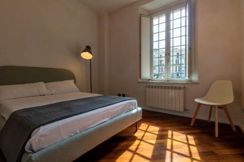 a bedroom with a bed and a chair and a window at Apartment Next to St Peter in Rome