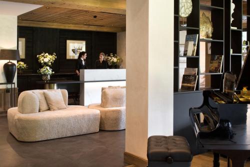 a salon with two women standing in the background at Domaine de Montagne - Hôtel Chalet Frère Joseph in Ventron