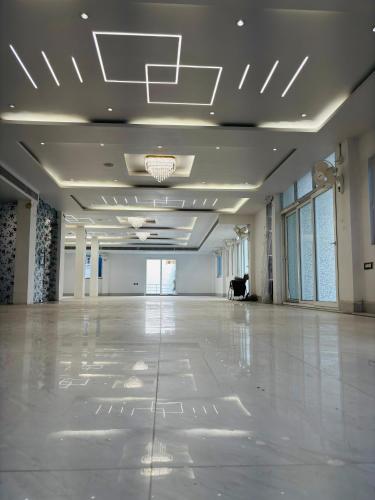 a large empty room with a white floor and ceilings at Hotel Maharani Grand Patna in Patna