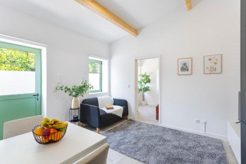 a living room with a bowl of fruit on a table at Bright Flat | Romantic Escape by HostWise in Porto