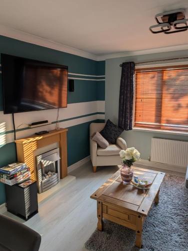 a living room with a fireplace and a tv at 2 Bedroom Guest House Near Beach in Llanelli