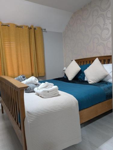 a bedroom with a bed with blue sheets and white pillows at 2 Bedroom Guest House Near Beach in Llanelli