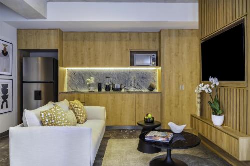 a living room with a white couch and a table at NH Guadalajara Studios in Guadalajara