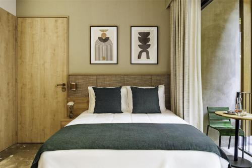 a bedroom with a large bed and a table at NH Guadalajara Studios in Guadalajara