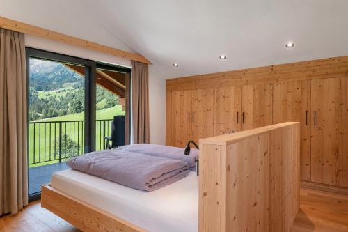 a bedroom with a bed and a large window at Mountain Chalet Tribulaun Pflersch in Colle Isarco